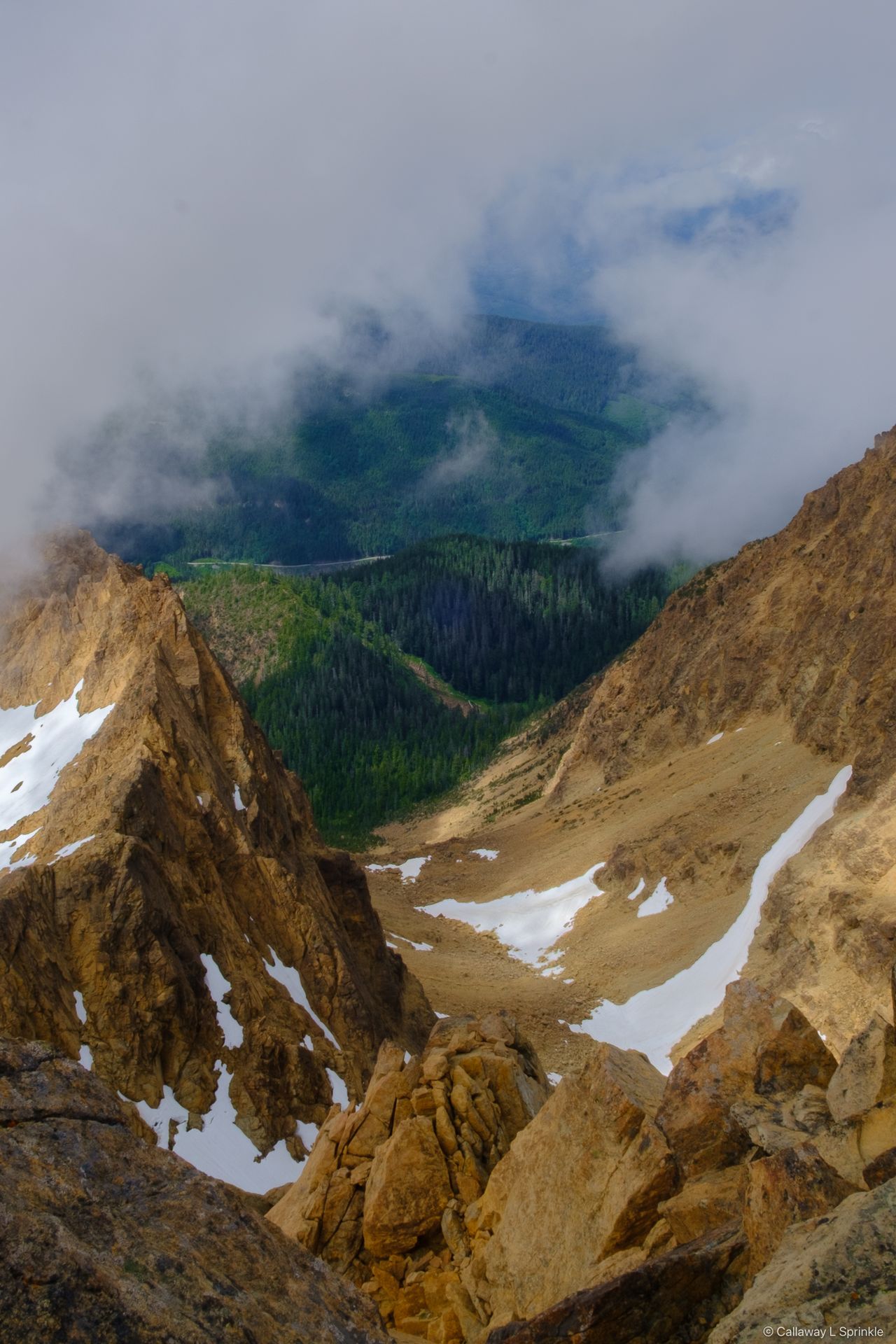 View from the summit down a cloud gap to the green forested valley of Green Creek far below